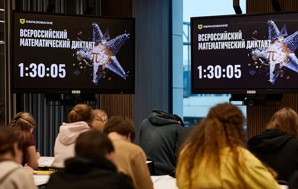Участники пишут диктант в зале, на экранах таймер и название мероприятия